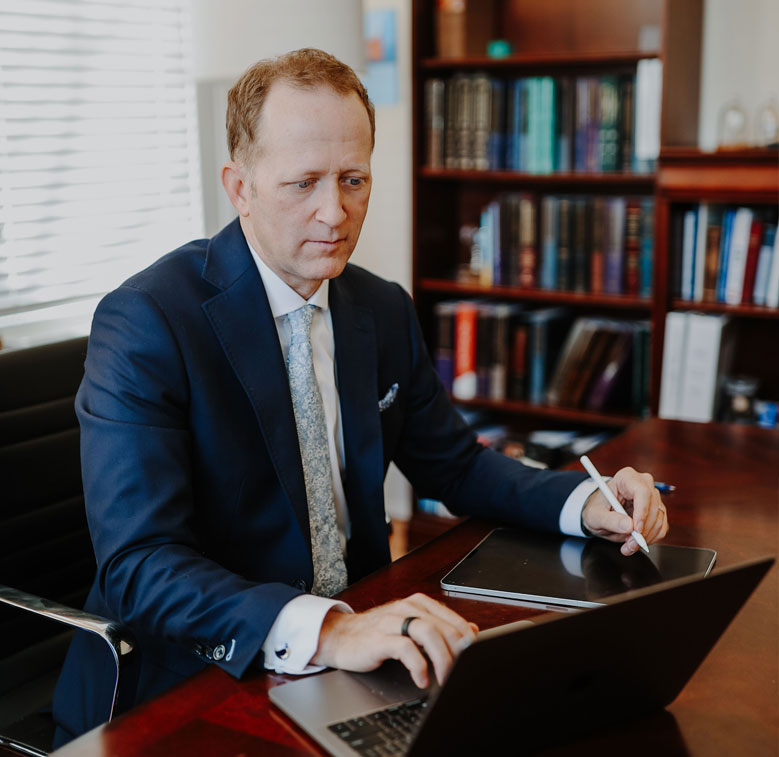 Attorney Dylan Wilbanks working on laptop in legal office